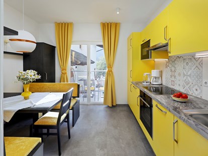 Pensionen - Wanderweg - Italien - Der elegante Wohnbereich mit Küche der gelben Ferienwohnung ist mit allen Annehmlichkeiten ausgestattet.   - Residence Sonnengarten**
